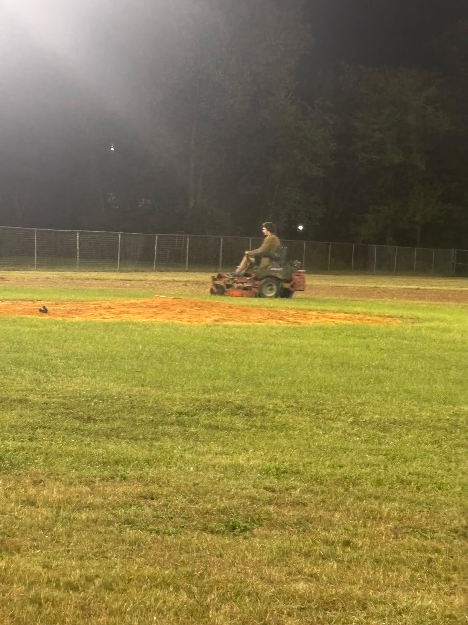 Drake mowing Tippy Field after dark